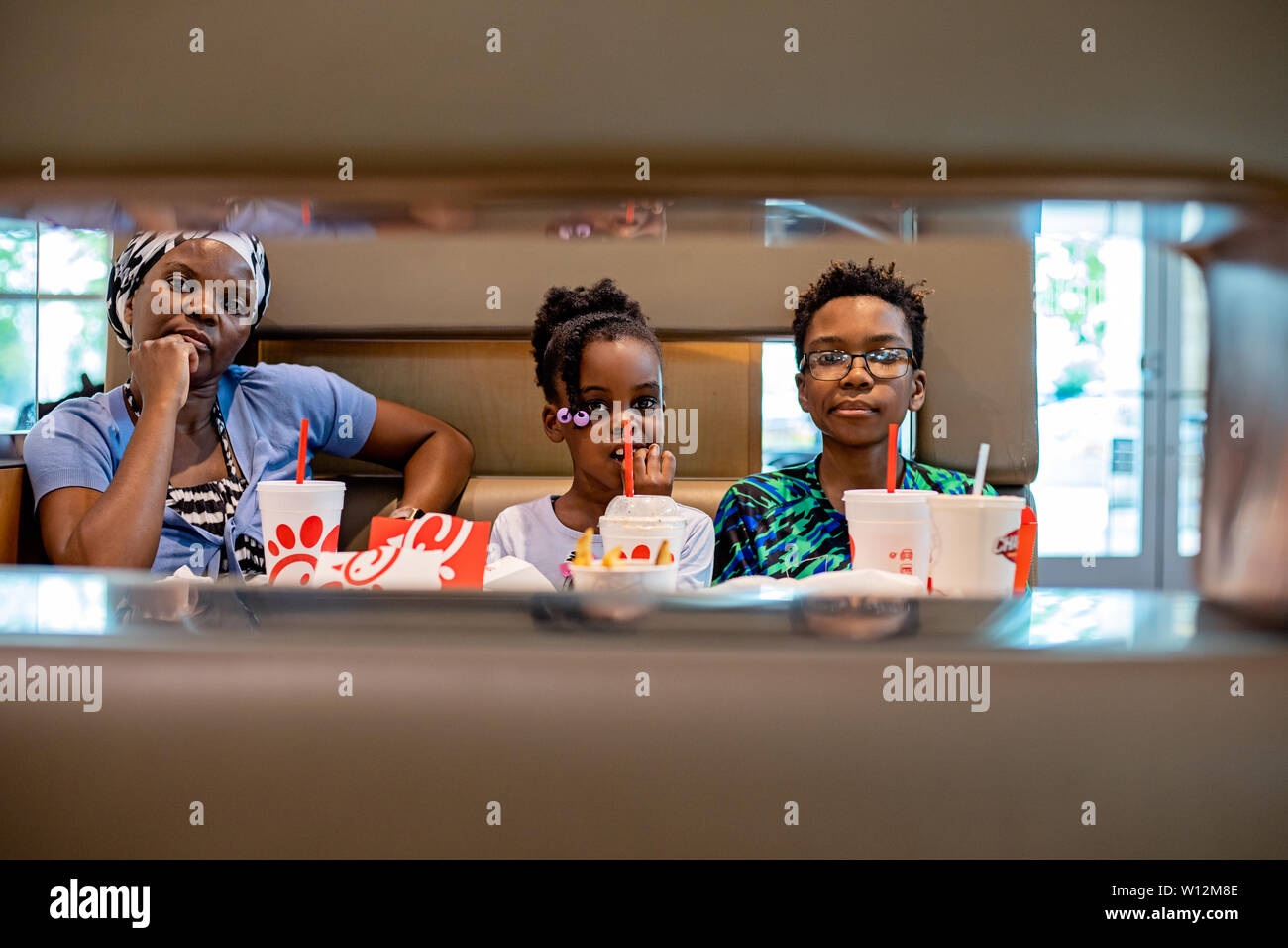 Eine schwarze Frau an einem Food Court osten Chic-Fit-A mit ihrem Sohn und Tochter sitzen Stockfoto