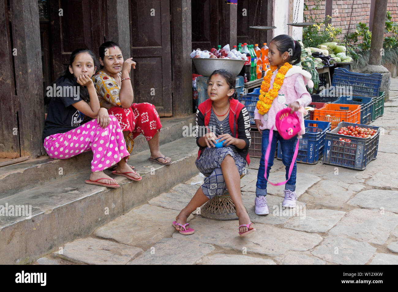 Frau und Kinder außerhalb des Shops auf alten Stone Street im historischen Newari Trading Post Stadt Bandipur, Tanahan Bezirk, Nepal Stockfoto