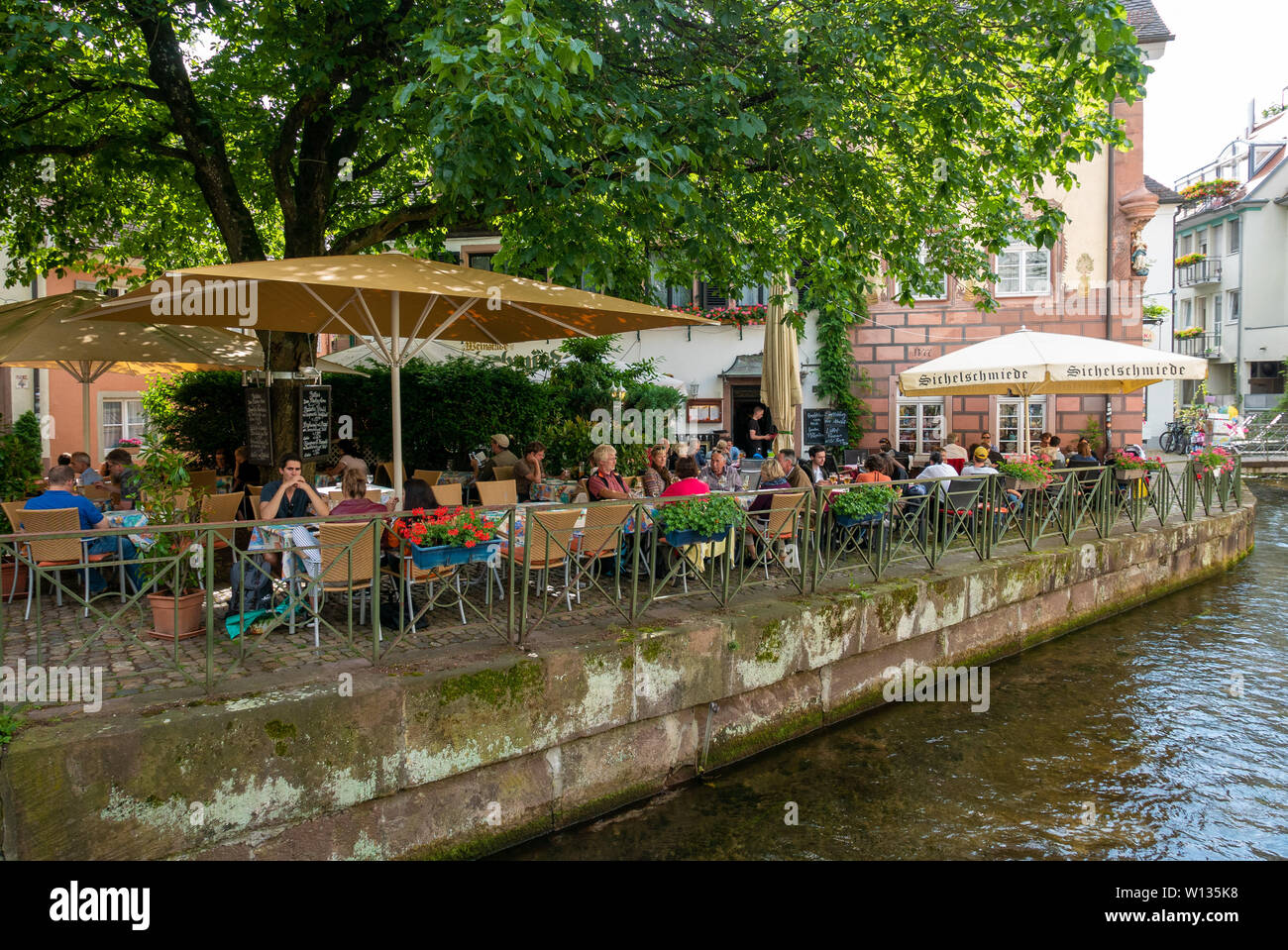 FREIBURG im Breisgau, Deutschland - Juni 15, 2019: Die Menschen auf den Terrassen der Bars und Restaurants neben den Kanälen Stockfoto