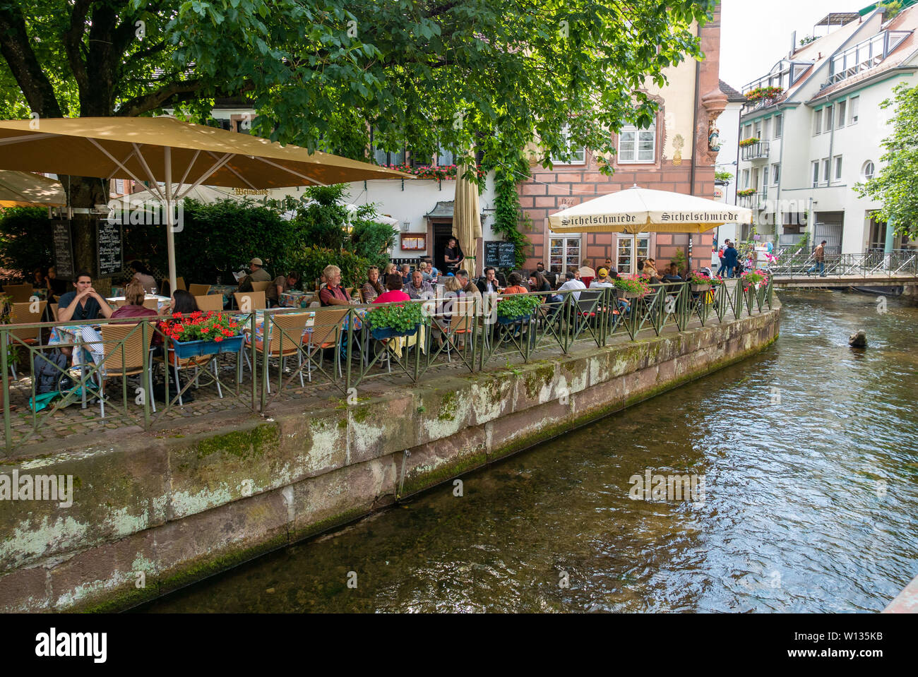 FREIBURG im Breisgau, Deutschland - Juni 15, 2019: Die Menschen auf den Terrassen der Bars und Restaurants neben den Kanälen Stockfoto