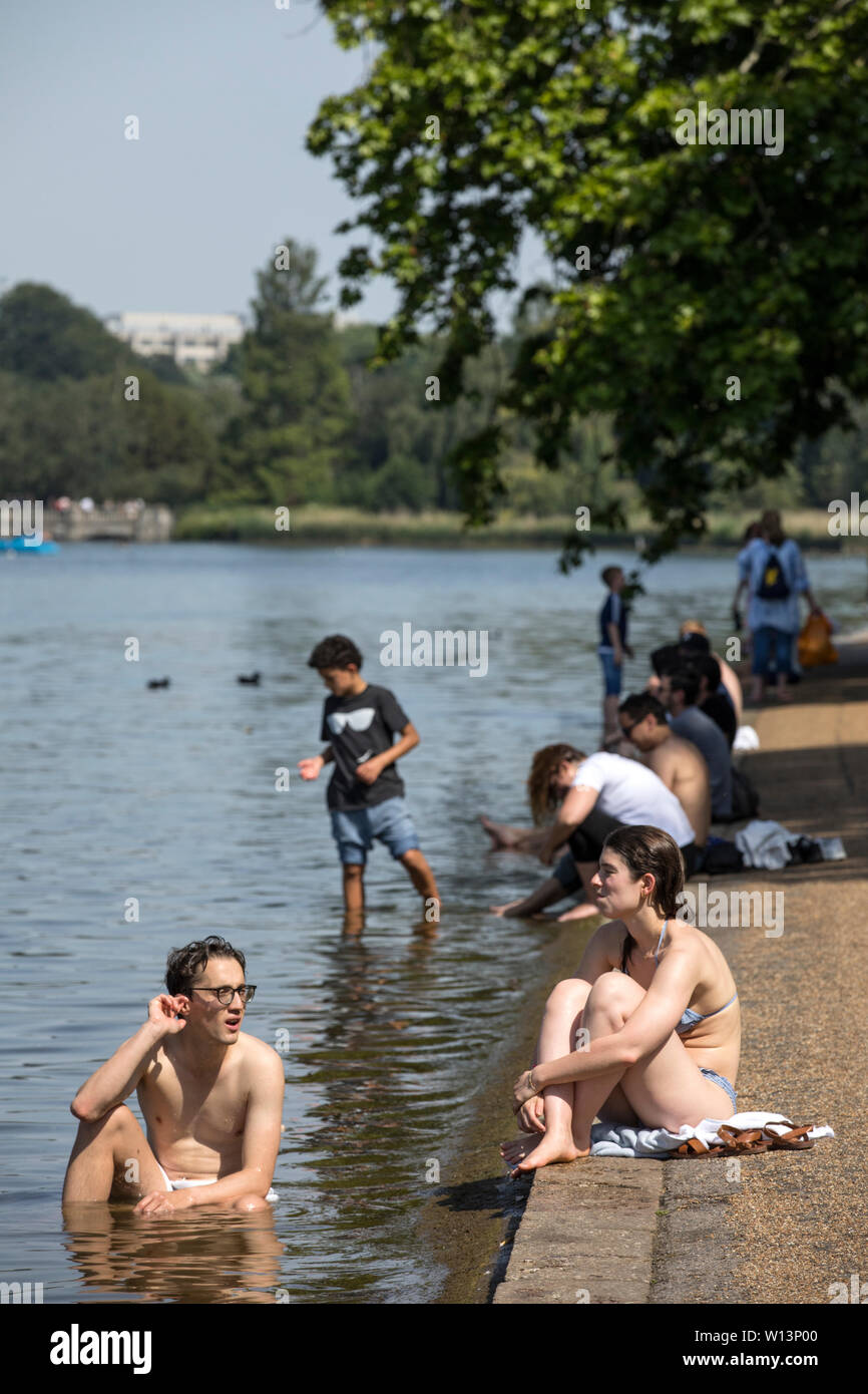 Touristen genießen den Sonnenschein in der Serpentine im Hyde Park, London. Eine der britischen aalt sich in 33 C Sonnenschein während der heißesten Tag des Jahres, den 29. Juni 2019 Stockfoto