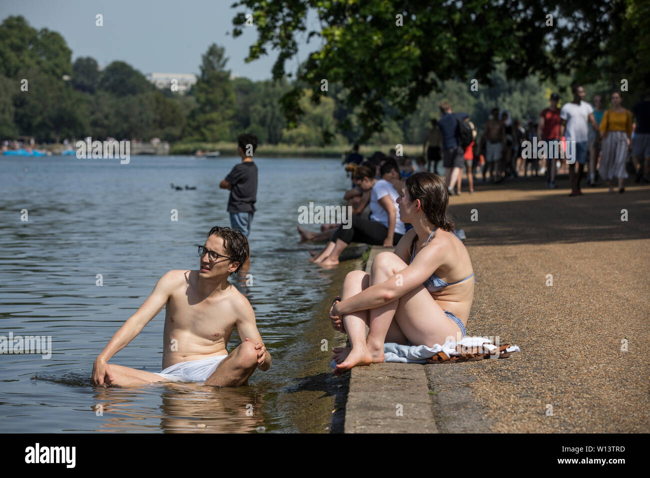 Touristen genießen den Sonnenschein in der Serpentine im Hyde Park, London. Eine der britischen aalt sich in 33 C Sonnenschein während der heißesten Tag des Jahres, den 29. Juni 2019 Stockfoto