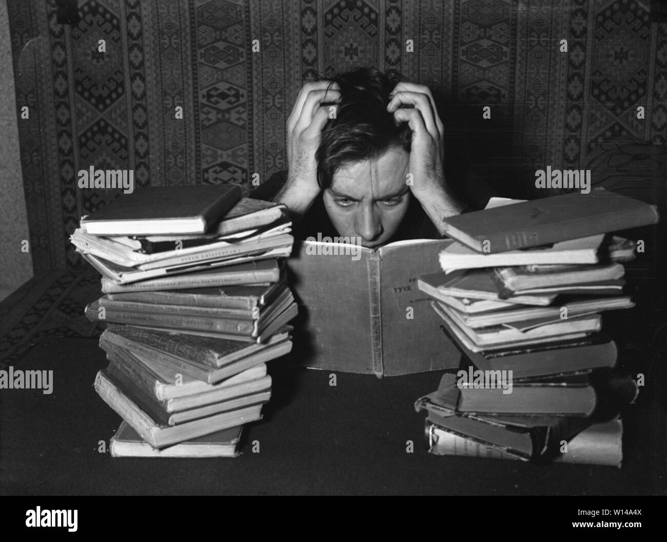 In den 1940er Jahren. Ein junger Mann mit seiner Studie Bücher vor ihm sieht so aus, als wenn er hart studiert. Er ist wirklich auf ein Buch konzentrieren und scheint zu Kämpfen zu lernen. Schweden 1940 Kristoffersson ref 75-5 Stockfoto