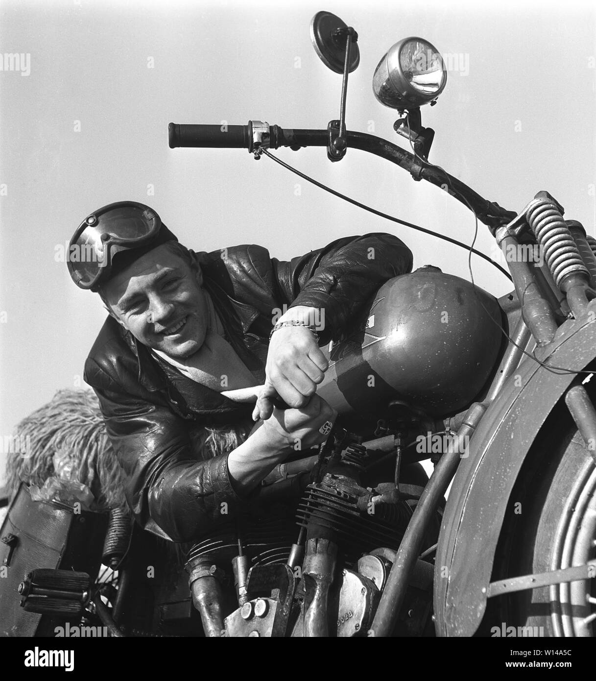 Der Motorradfahrer in den 1950er Jahren. Ein junger Mann mit Brille und einem Leder Cap mit seinem Motorrad. Das Motorrad ist der amerikanischen Firma Excelsior in Chicago und das Modell ist Super-X 1925, und war Amerika erste Motorrad mit Zweizylinder-V-Motor. Schweden 1950 s Ref 10-09-11 Stockfoto