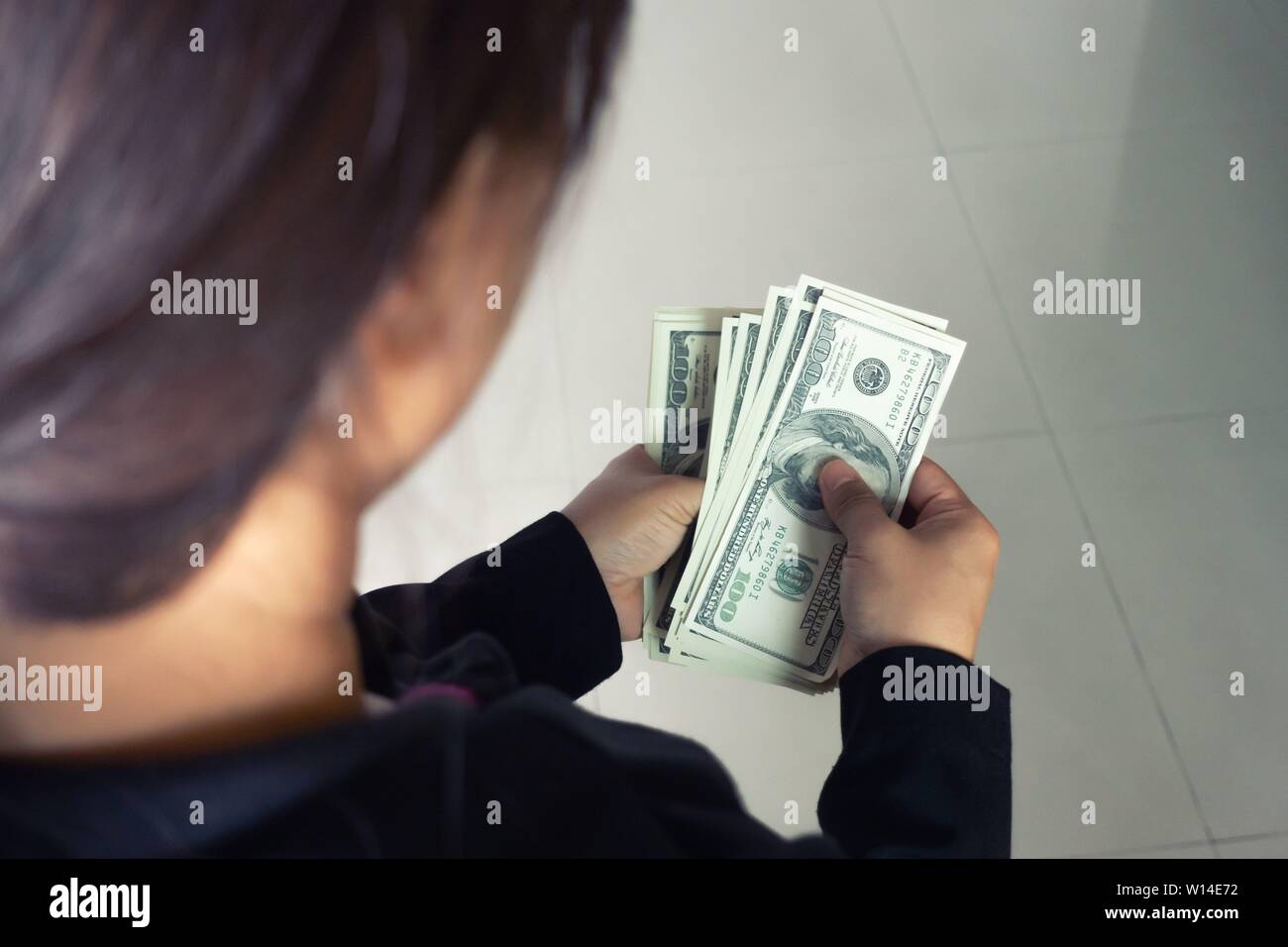 Frau aus Geld Dollar Banknoten aus Wallet Stockfoto