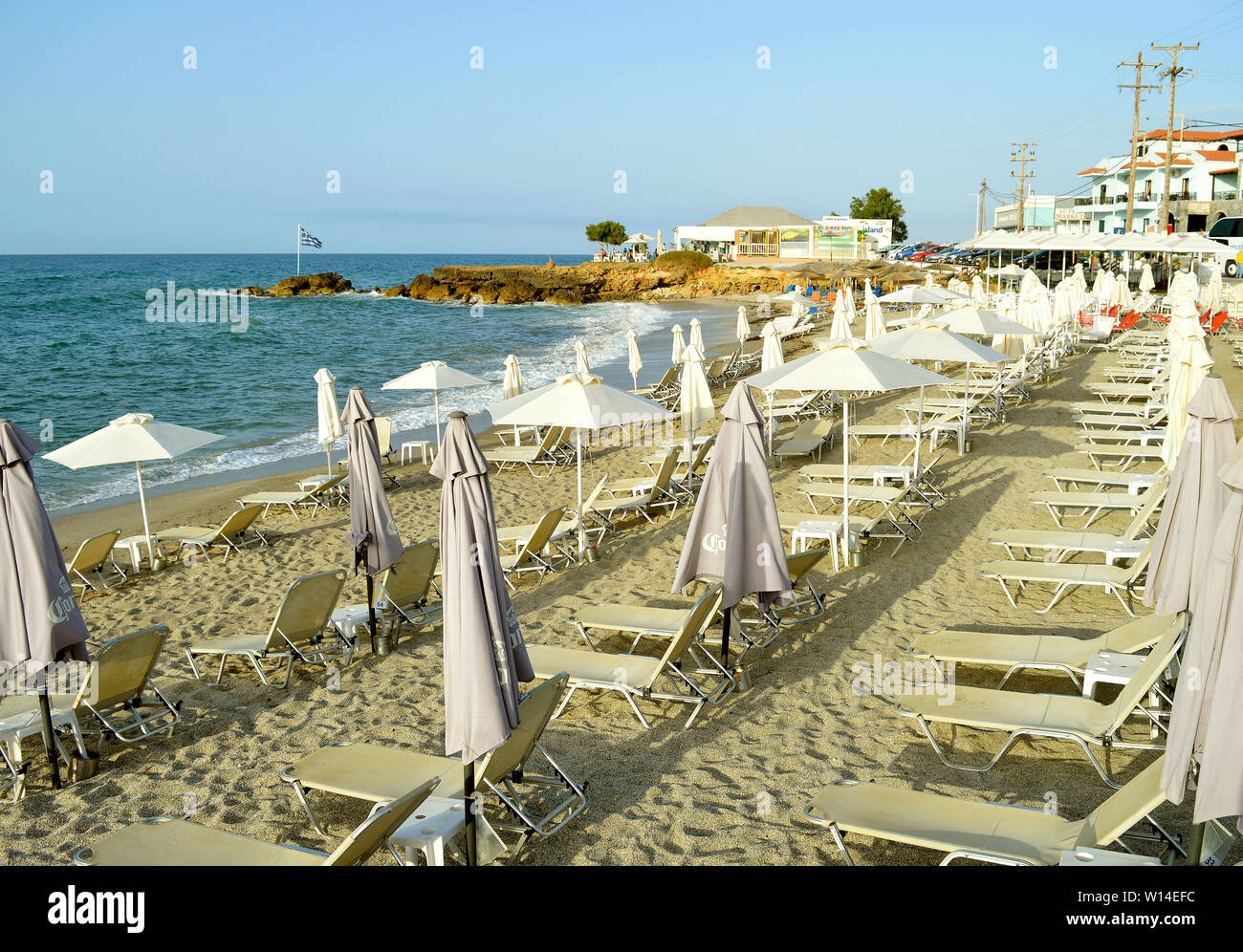 Sonnenschirme und Touristen am Strand von Gouves auf Kreta die größte und bevölkerungsreichste der griechischen Inseln Stockfoto