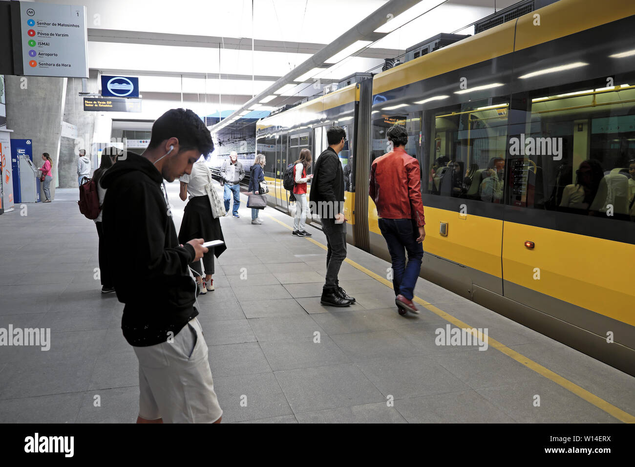 Junger Mann mit Kopfhörer an seinem Iphone Musik suchen, sms in den U-Bahnhof Porto Oporto Portugal Europa KATHY DEWITT Stockfoto