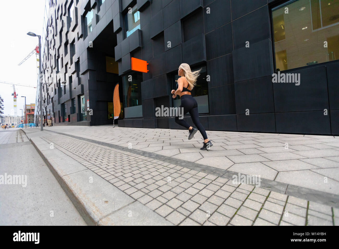 Rückansicht eines schnell laufenden passende Frau in der modernen Stadt Umgebung Stockfoto