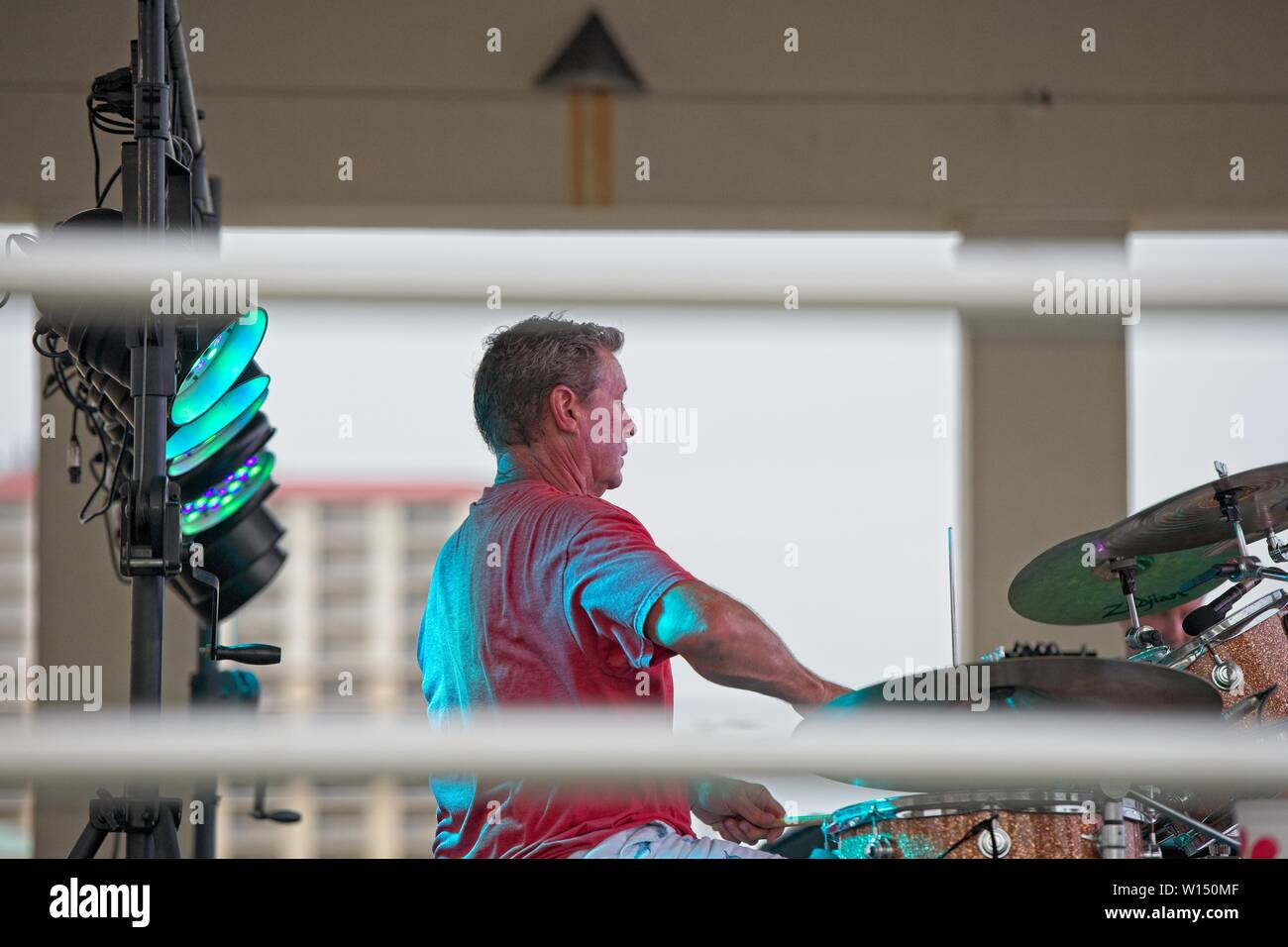 Ein Seitenansicht eines Schlagzeugers, der bei einem Outdoor-Rockkonzert seine Trommeln spielt Stockfoto