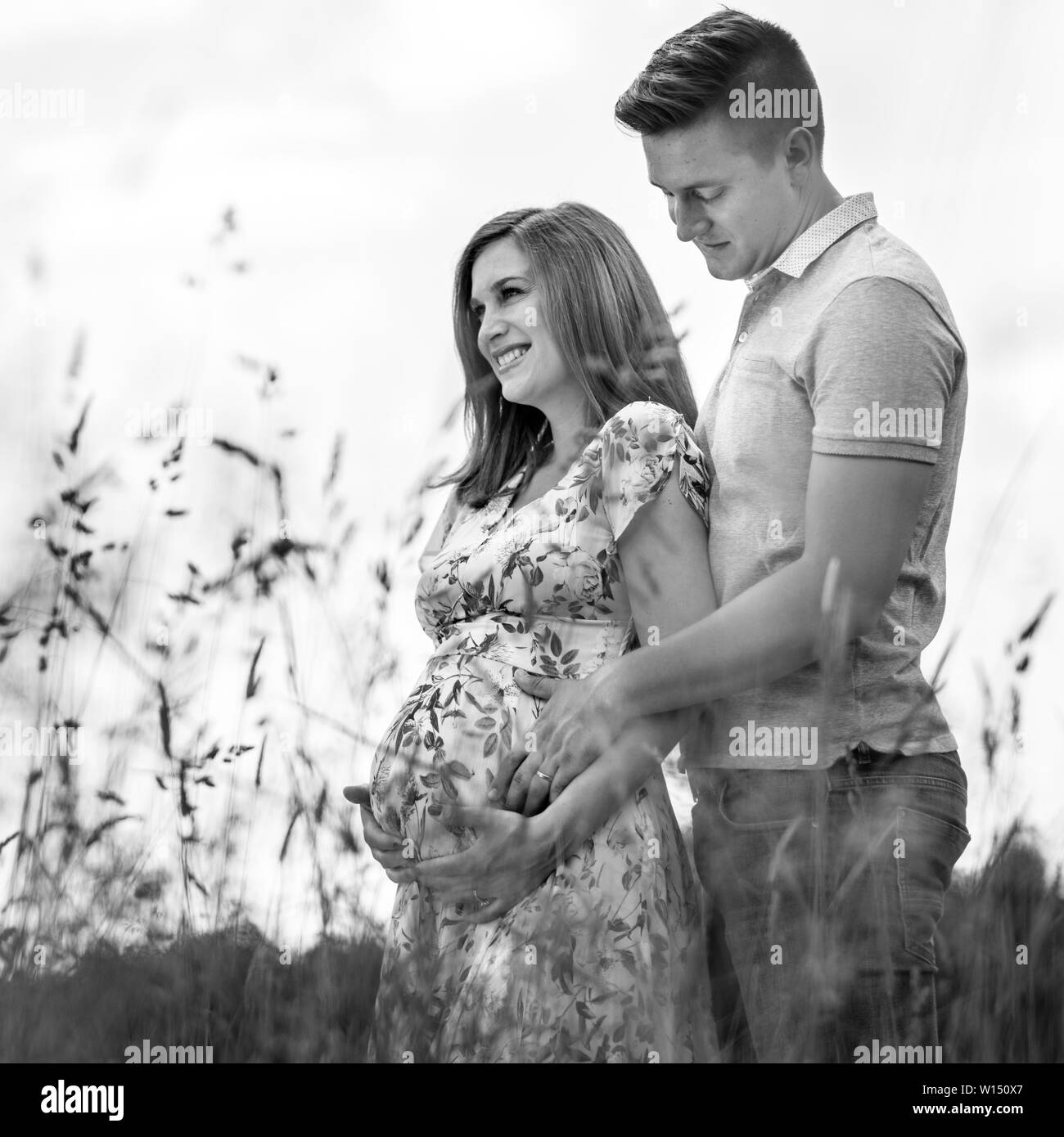Junge glücklich schwanger Paar umarmen in der Natur. Stockfoto