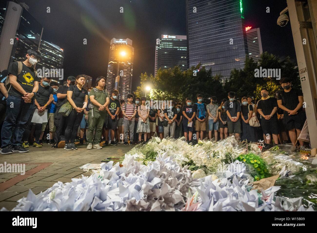 Anti Auslieferung bill Demonstranten während der eine Minute stille Hommage an die 21 Jahre, die aufgrund der Politik der Regierung über die Auslieferung bill Protestprozessionen zu Zahlen gesehen. Hunderte versammelten sich in der Nähe des Hong Kong Verwaltungssitz der komplexen Tribut an eine 21-jährige Studentin, die scheinbar zu ihrem Tod nach dem Schreiben eine letzte Meldung auf einer Wand kritisiert die Politik der Regierung von Hongkong der Auslieferung Rechnung am Tag zuvor sprang zu bezahlen. Stockfoto