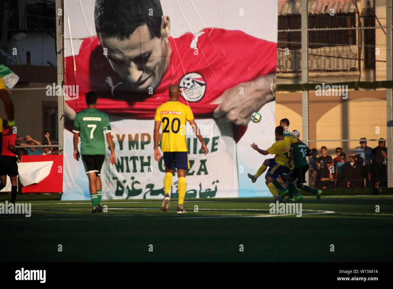 Rafah, Gaza, palästinensischen Gebiet. 30. Juni, 2019. Ein Plakat der Ägyptischen Fußball-Spieler Mohammed Abu Trika ist bei einem Match zwischen palästinensischen Spielern Khadamat Rafah Club (Green-T-Shirt) und Spieler der Balata Jugend Club (gelben T-Shirt) gesehen, in der Palästina Cup Meisterschaft, in Rafah im südlichen Gazastreifen am 30. Juni. 2019. Das Spiel endete mit einem 1:1-Unentschieden im Hinspiel der Palästina Cup Final Credit: Mahmoud Ajjour/APA-Images/ZUMA Draht/Alamy leben Nachrichten Stockfoto