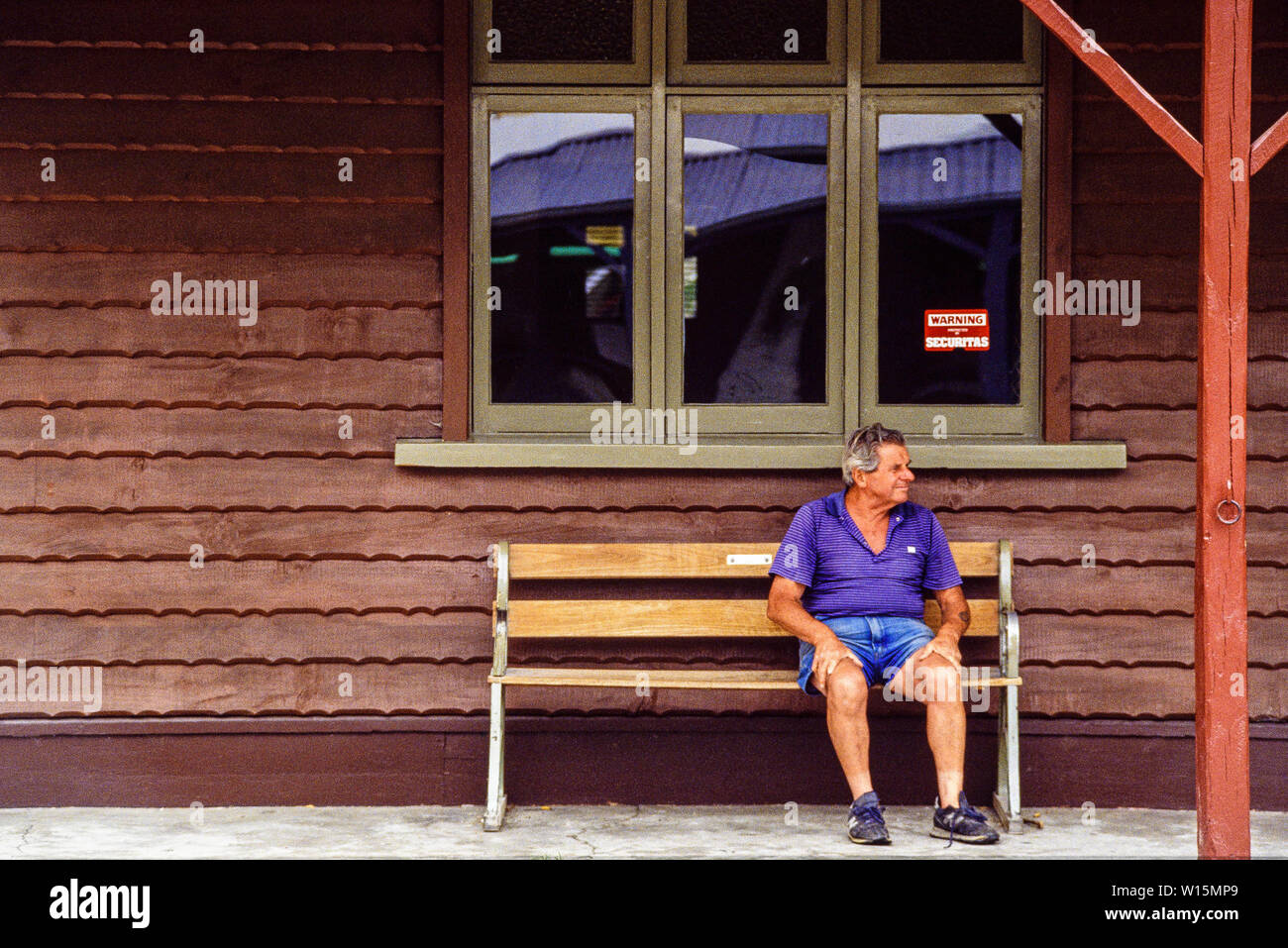 Neuseeland, Südinsel, Arrowtown. Ein Tourist nimmt eine Pause auf einer Bank sitzen. Eine historische Goldgräberstadt in der Region Otago. Foto November Stockfoto