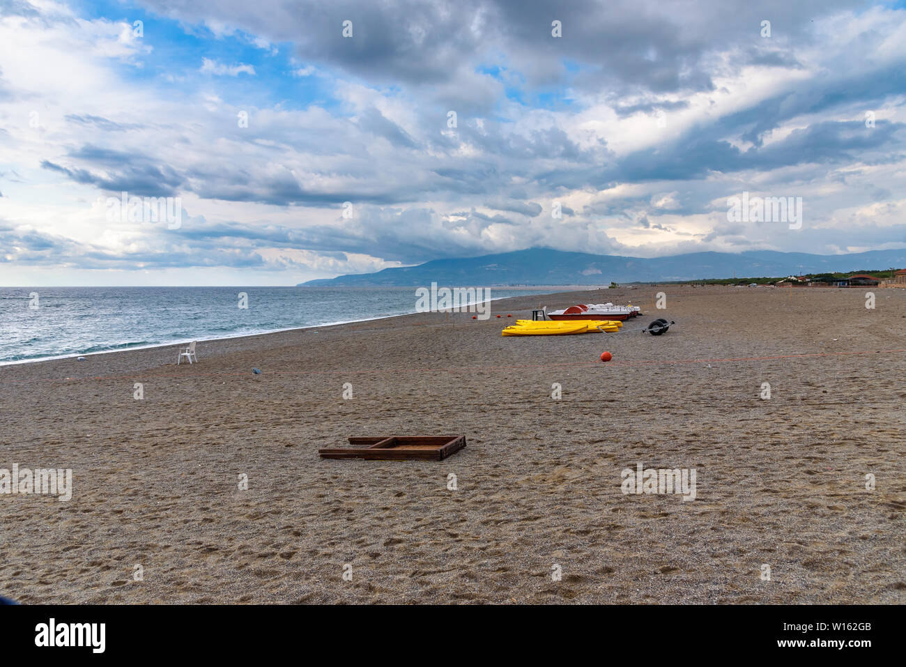 Tretboote und Kajaks auf eine Kies Strand am Tyrrhenischen Meer in Kalabrien, Italien Stockfoto