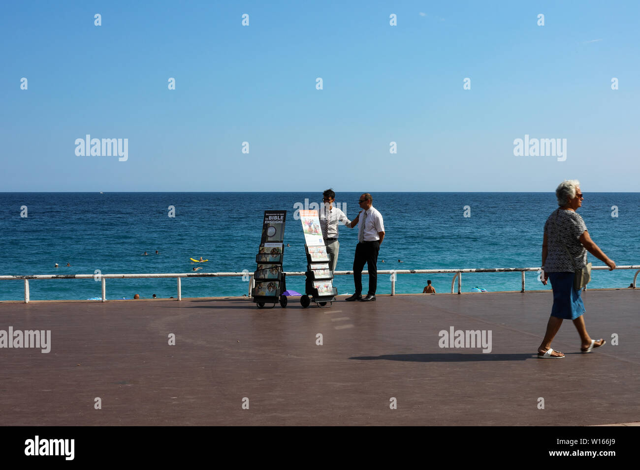 Zeugen Jehovas verteilen Illustrierte religiöse Zeitschriften über die Promenade des Anglais in Nizza, Frankreich Stockfoto