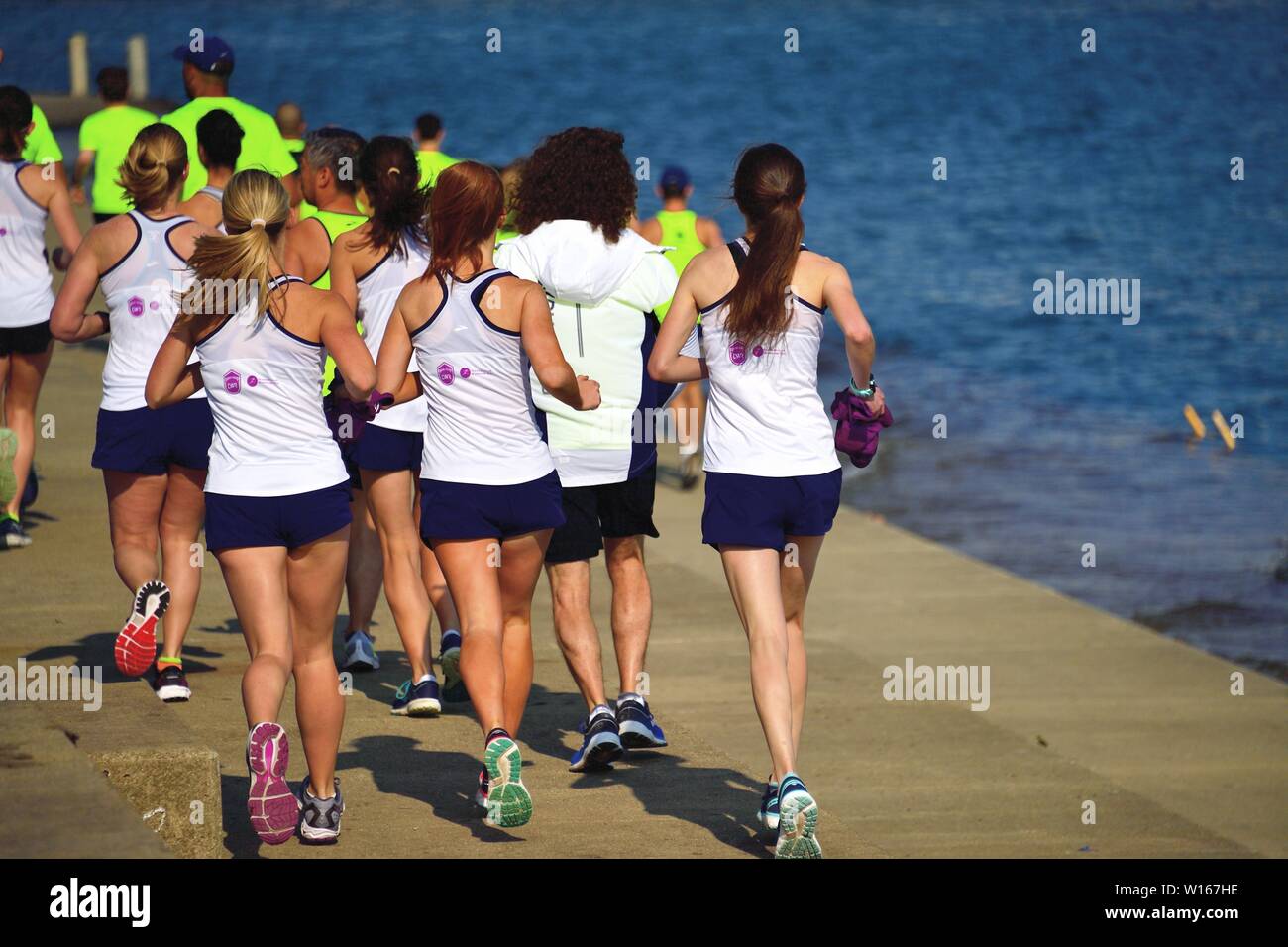 Chicago, Illinois, USA. Mitglieder eines laufenden Club laufen auf einem See an der Wand entlang des Lake Michigan als Teil einer Gruppe von Rettungsschwimmern in der Ausbildung. Stockfoto