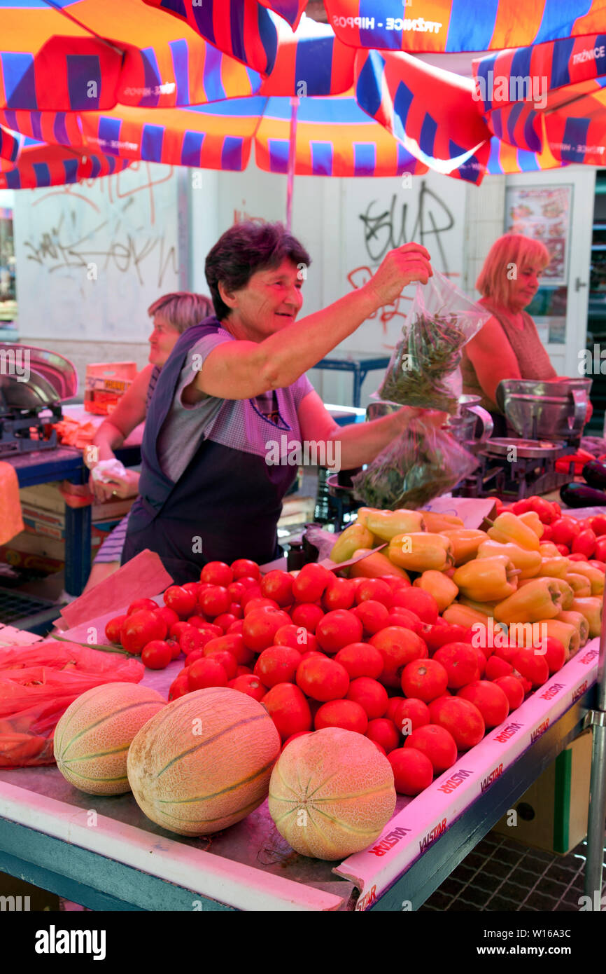 Obst und grünen Vendor holding Taschen von Kräutern. Öffentliche Blume und Produzieren Markt neben der Diokletianspalast, Split, Kroatien. Stockfoto