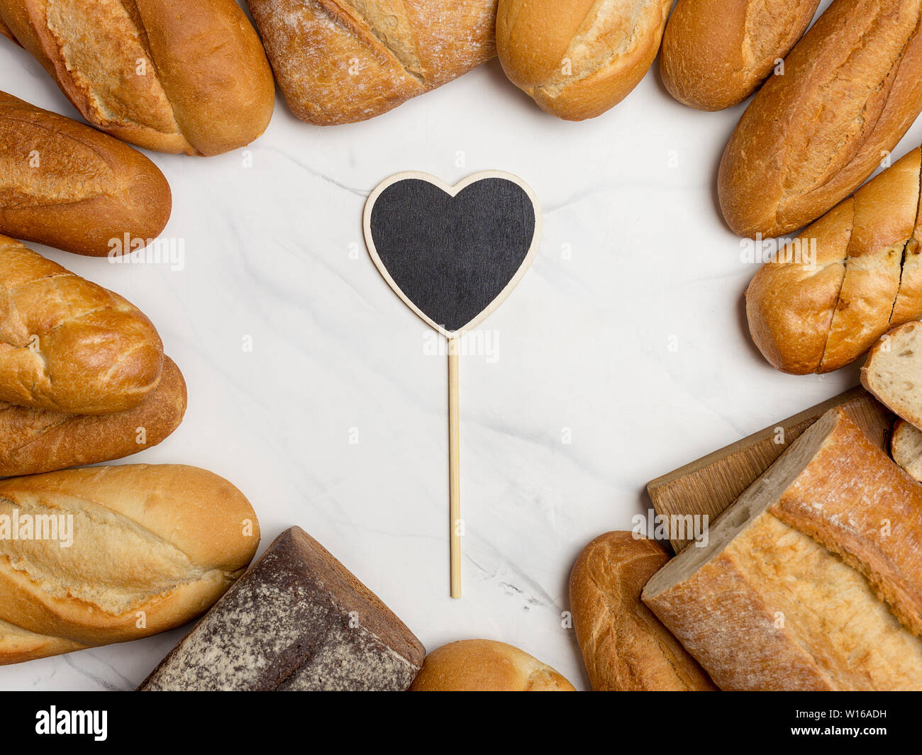 Brot am Rand auf weißem Hintergrund mit Herzen am Zentrum für Ihren Text. Flach, horizontale Ansicht von oben Stockfoto