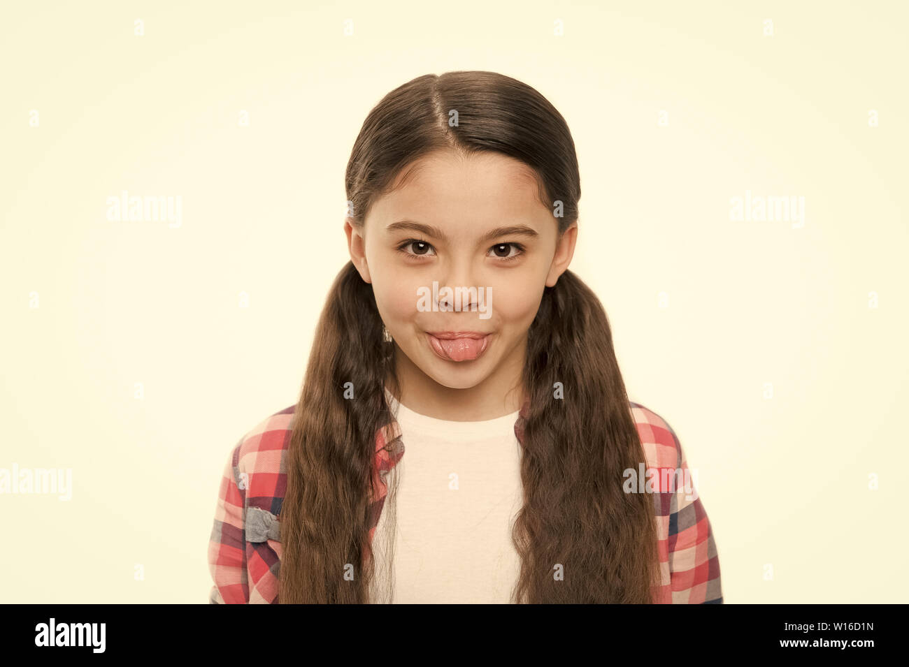 Wird ein echter Cutie. Kleines Kind mit Brünette Haare mit Zunge. Nettes Mädchen mit langen Frisur. Kleines Mädchen mit stilvollen Pferdeschwanz Frisur. Kleine Haare Modell mit Schönheit. Friseursalon für Kinder. Stockfoto