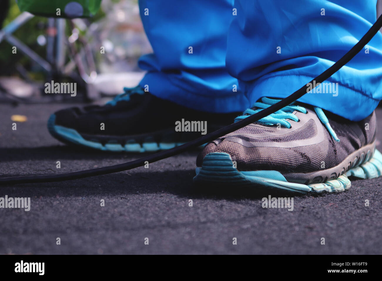 Blaue Schuhe auf einem schwarzen Teppich Verschleiß Stockfoto