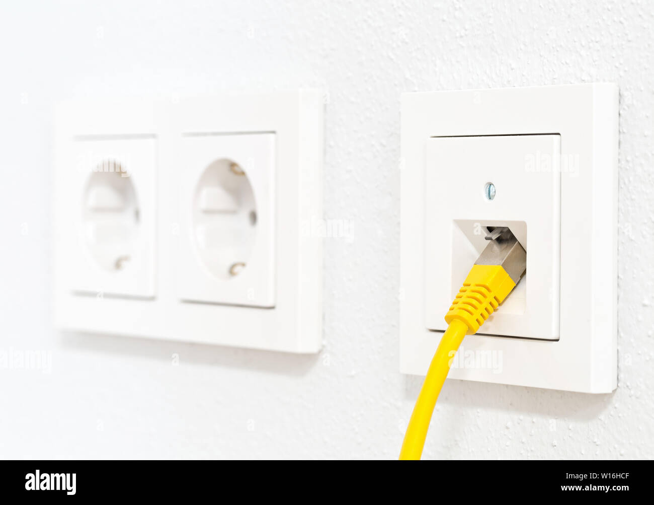 Gelbe Kabel in Steckdose für Büro oder private LAN-Ethernet-Anschluss mit  Steckdosen flache Ansicht auf weiß verputzten Wand Hintergrund  Stockfotografie - Alamy