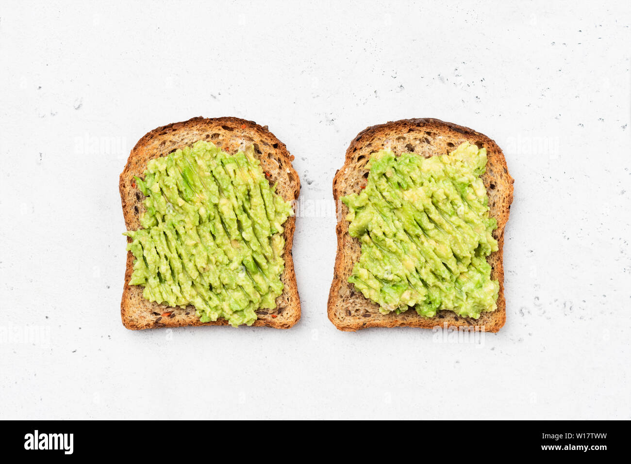 Avocado Toast auf Vollkorn sandwich Brot. Tabelle Ansicht von oben. Guacamole Toasts. Konzept der gesunden Ernährung, Diäten, vegan vegetarische Kost Stockfoto