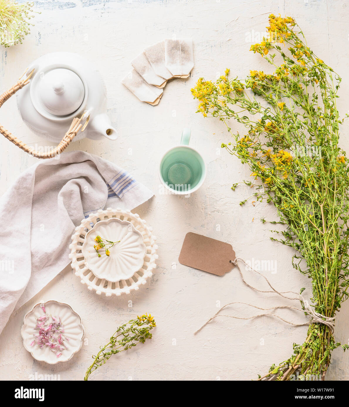 Weißer Tee auf Licht Tabelle mit heilenden Kräutern und Blumen Strauß, Ansicht von oben. Kräutertee mit Kopie Raum für Ihr Design oder Produkt. Organische Tutsan te Stockfoto