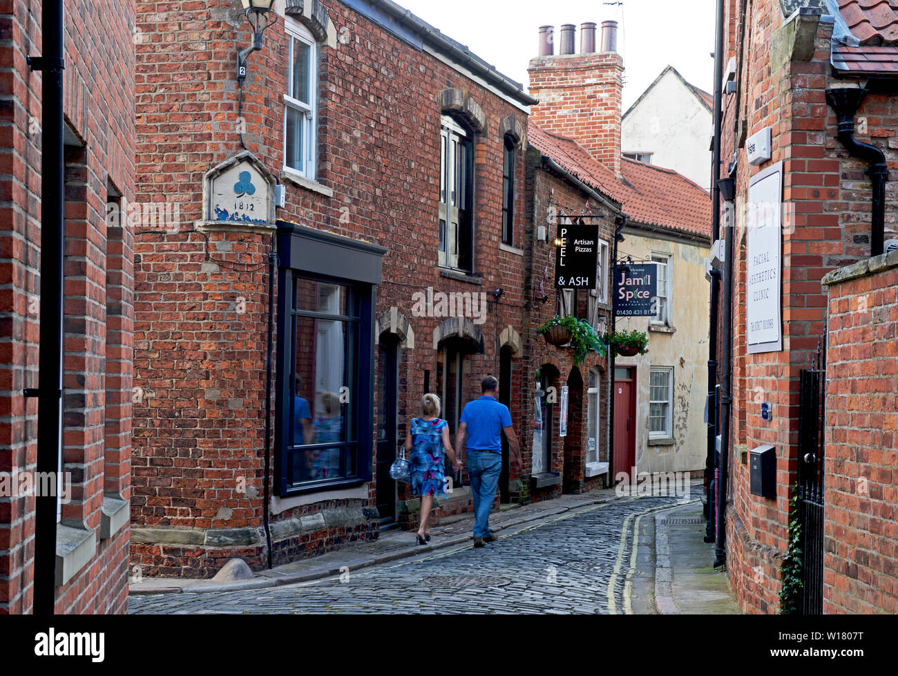 Paar mittleren Alters zu Fuß durch die Straßen von Howden, East Yorkshire, England, Großbritannien Stockfoto