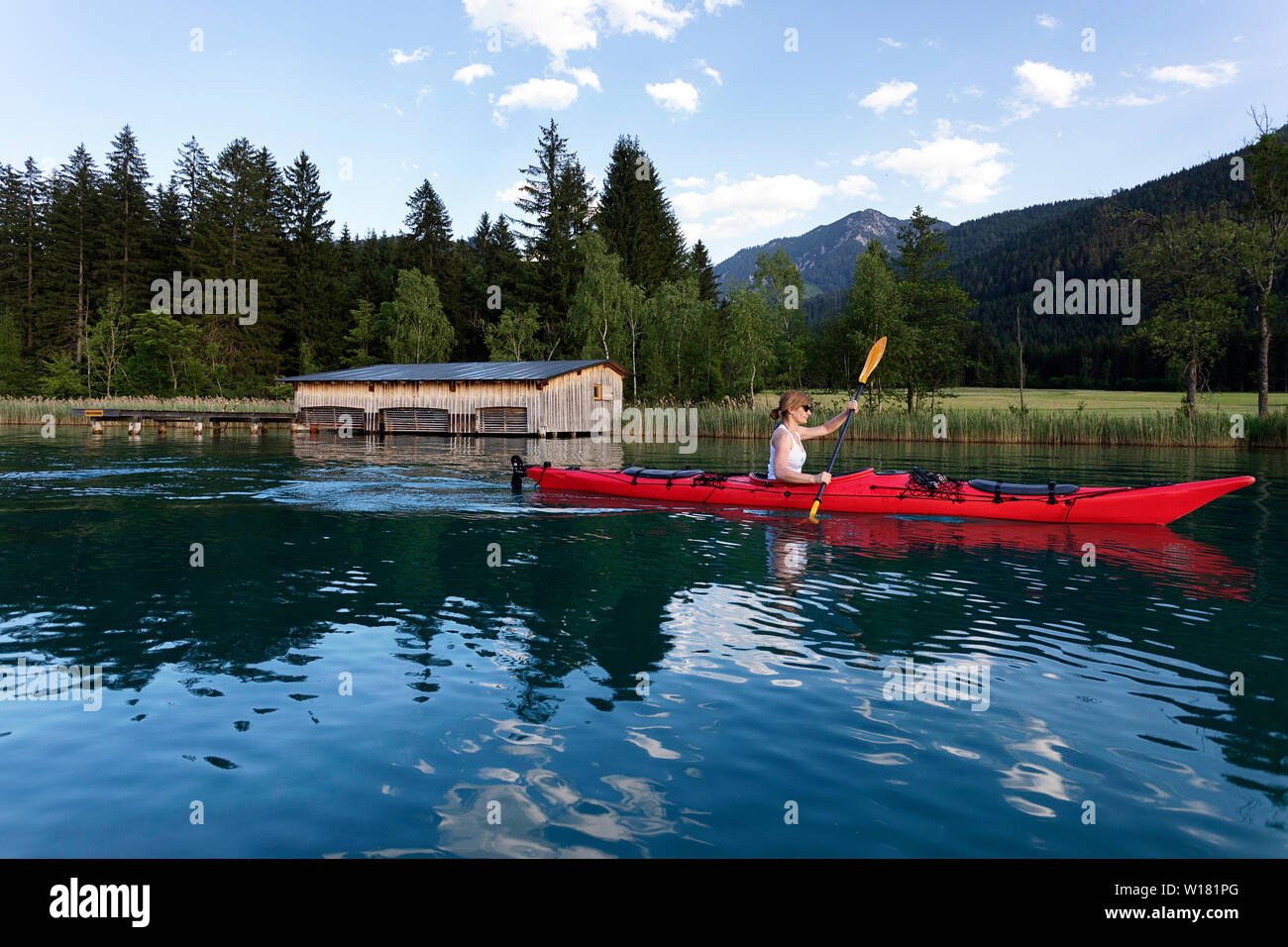 Frau Kajak bei Sonnenuntergang in Weissensee, Österreich Stockfoto