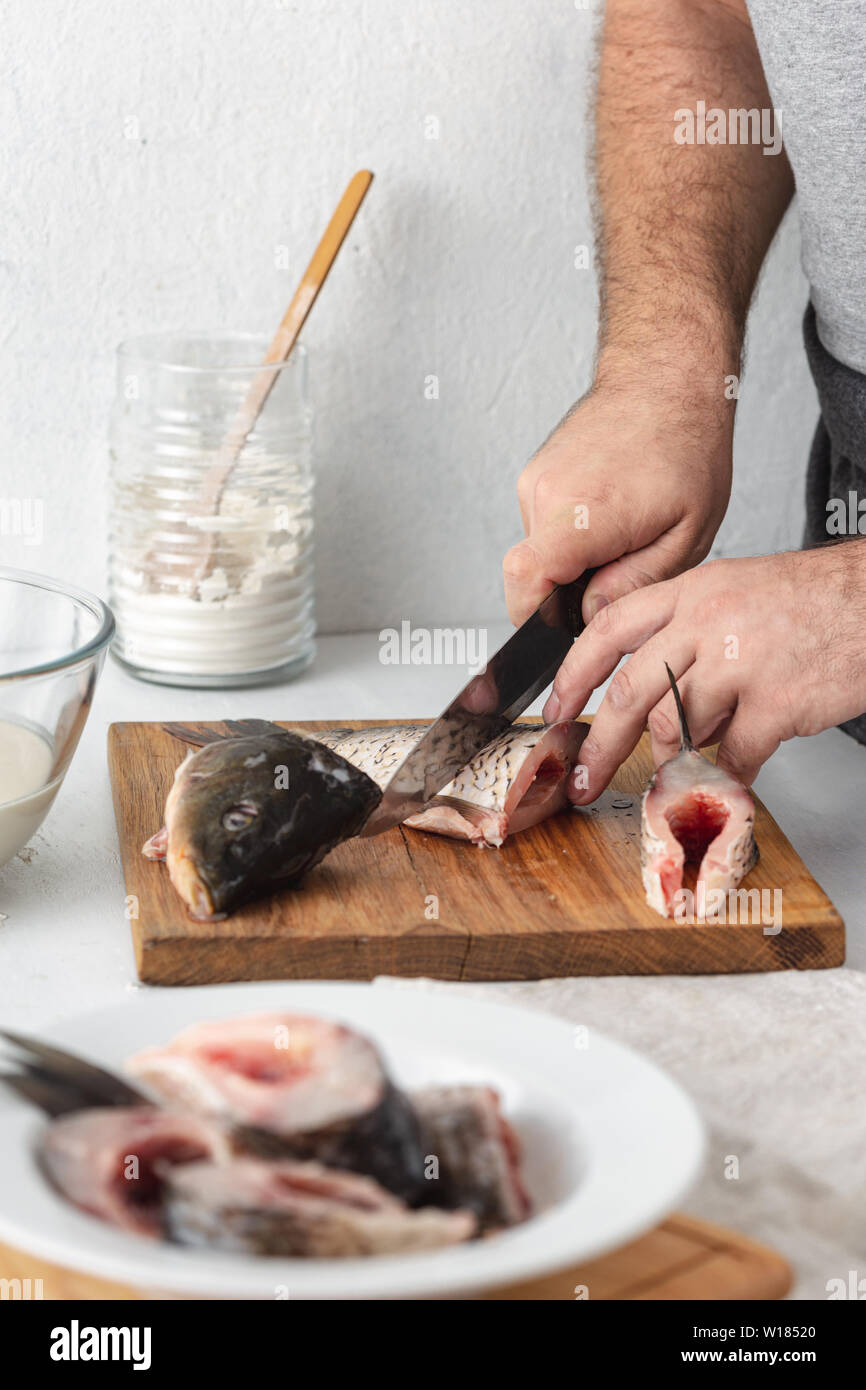 Der Mensch bereitet Karpfen Fluss Fisch in der Küche zu Hause. Kochen gesund und Ernährung Lebensmittel Stockfoto