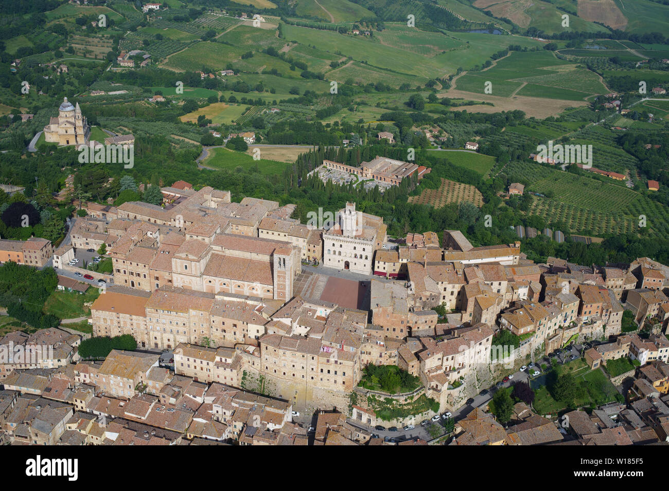LUFTAUFNAHME. Mittelalterliche Stadt auf einem Hügel, die das Ackerland des Val di Chiana und die Kirche San Biagio beherrscht. Montepulciano, Provinz Siena, Toskana, Italien. Stockfoto