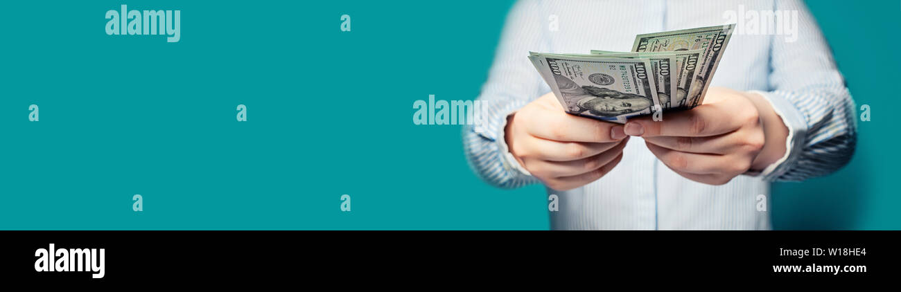 Hände mit Geld US-Dollar auf blauem Hintergrund banner Stockfoto