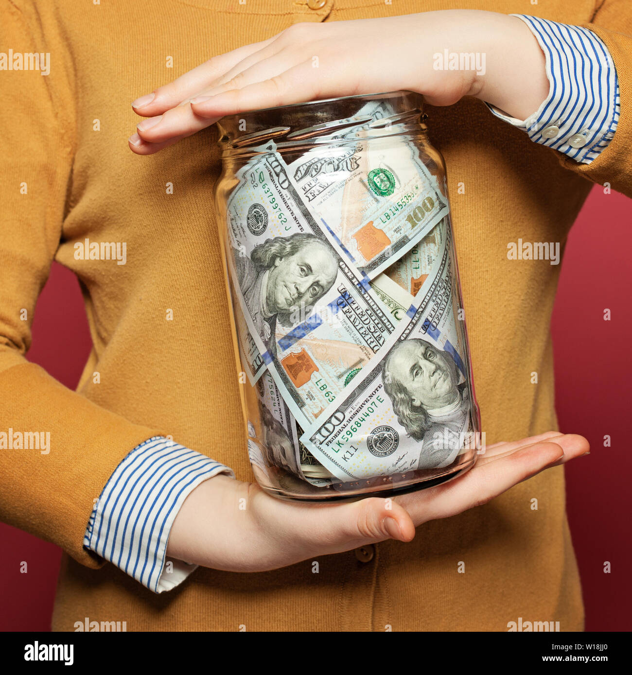 Bargeld in US-Dollar in den jar auf bunten hellen Hintergrund. Geld sparen Konzept Stockfoto