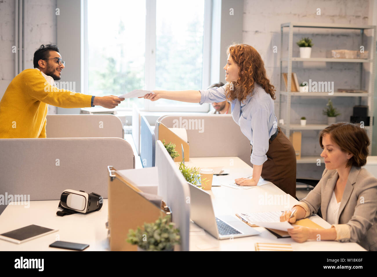 Gruppe von jungen Spezialist bei SEO-Abteilung Arbeiten qualifiziert: hipster Mann vorbei an analytischen Papiere zu Kollege im Büro Stockfoto