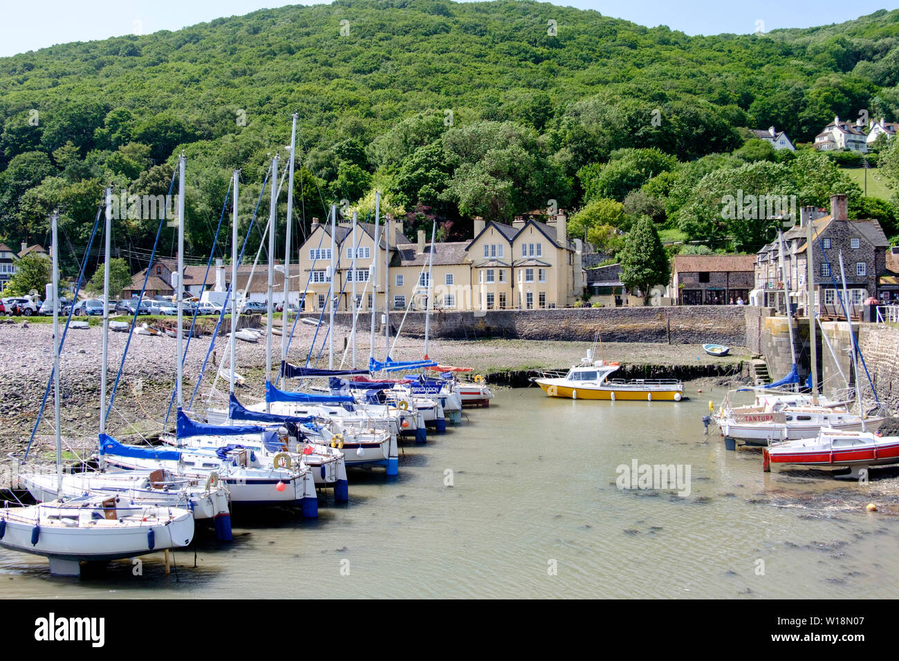 Um Porlock Wehr, einem kleinen Dorf an der Küste North Somerset. Großbritannien einige Boote und Yachten mit dem Anker Hotel im Hintergrund Stockfoto