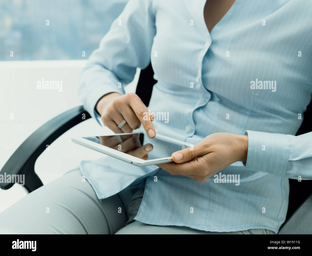 Professionelle Geschäftsfrau, sitzen auf einem Bürostuhl und Anschließen mit einem digitalen Touchscreen tablet, Business und Kommunikation Konzept online Stockfoto