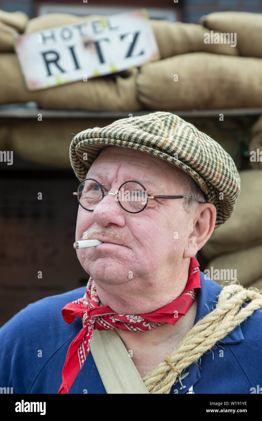 Kidderminster, Großbritannien. Juni 2019. Severn Valley Railways 'Step Back to the 40s' beginnt an diesem Wochenende mit einem fabelhaften Start mit kostümierten Umbenennern, die ihre Rolle bei der Bereitstellung einer authentischen Erholung von Wartime Britain spielen. Ein Porträt, Vorderansicht, Nahaufnahme eines Mannes, der als alter ARP-Warden verkleidet ist, steht im luftschutzhaus, das komisch "Hotel Ritz" genannt wird. Charakterportraitfotografie: Mann in tweed flacher Kappe mit Zigarette im Mund. Kredit: Lee Hudson Stockfoto