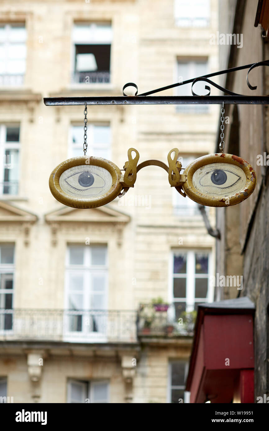 Paar gold Brille mit blauen Augen - Kreative shop Sign Design hängt über einem Optiker Shop in einer Straße in Bordeaux Stockfoto