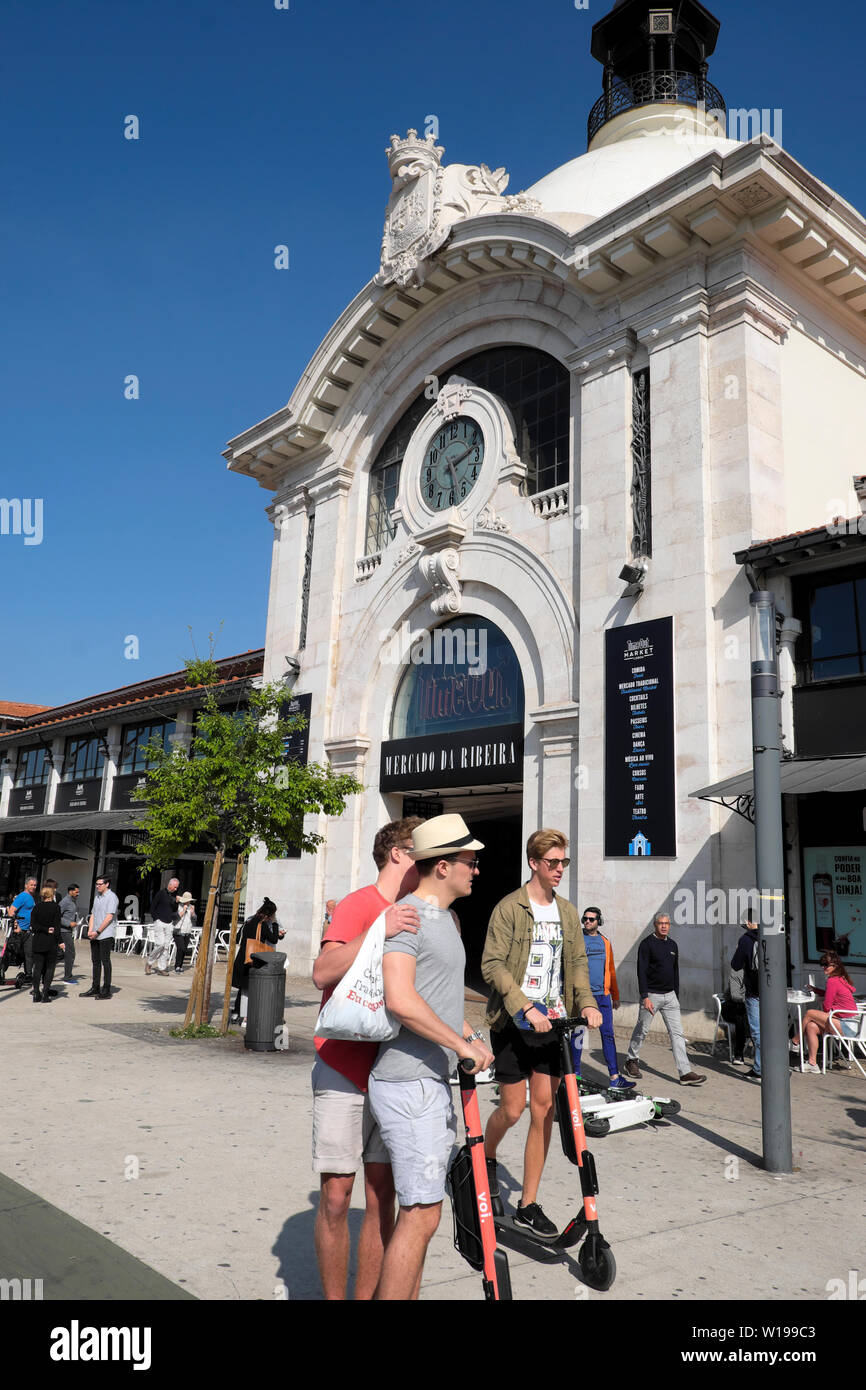 Junge Männer auf Elektroroller in der Straße vor dem Time Out Food Market in Lissabon Portugal Europa EU-KATHY DEWITT Stockfoto
