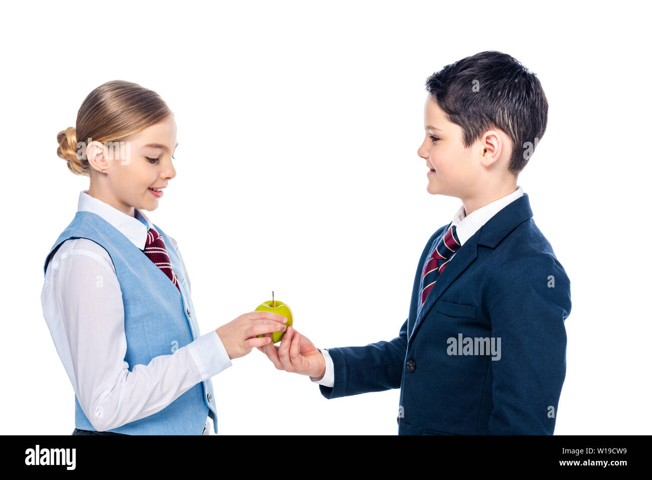 Schulkinder in formalen Verschleiß teilen Apple isoliert auf weißem Stockfoto