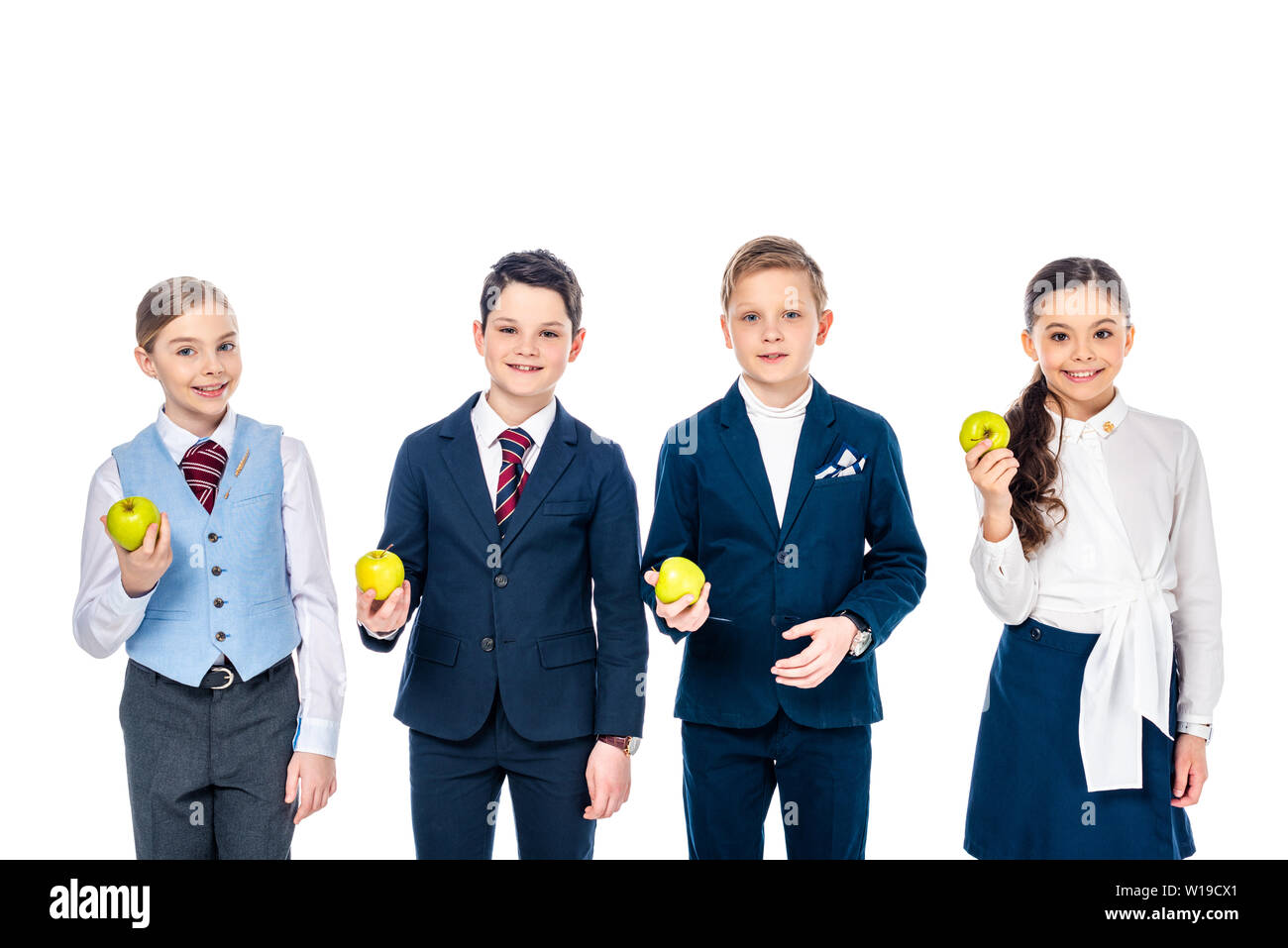Lächelnd Schulkinder vorgibt, Geschäftsleute, die sich mit Äpfeln isoliert Auf, Weiß zu sein Stockfoto