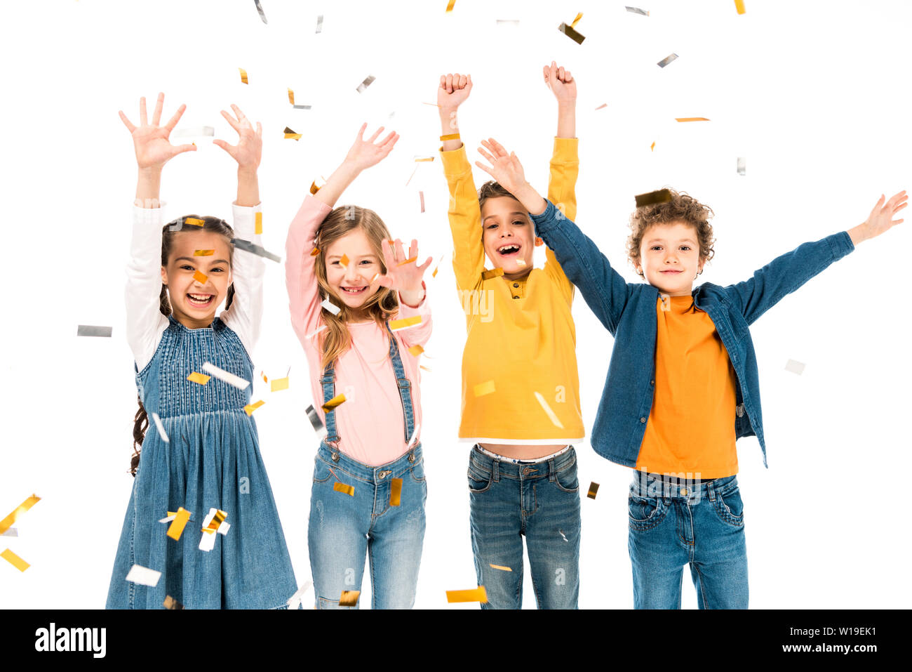 Vier Glückliche Kinder winkende Hände unter Konfetti isoliert auf weißem Stockfoto