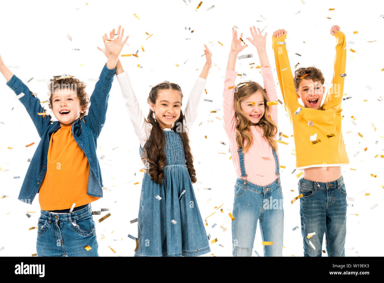 Vier Glückliche Kinder winkende Hände unter Konfetti isoliert auf weißem Stockfoto