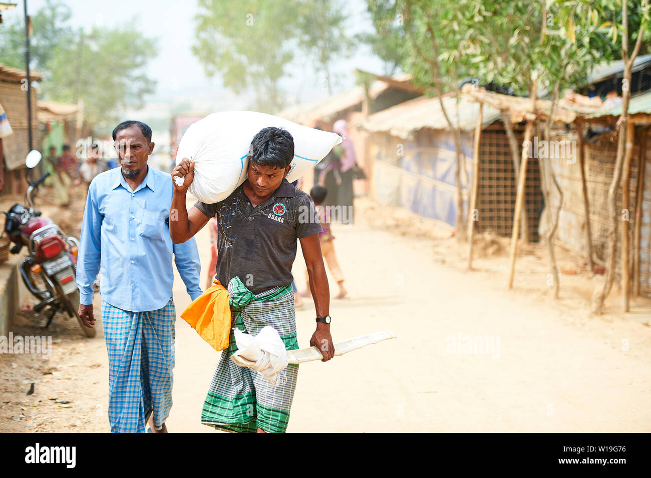 Mann, der Sack Reis in Kutupalong Rohingya Flüchtlingslager, Bangladesch Stockfoto