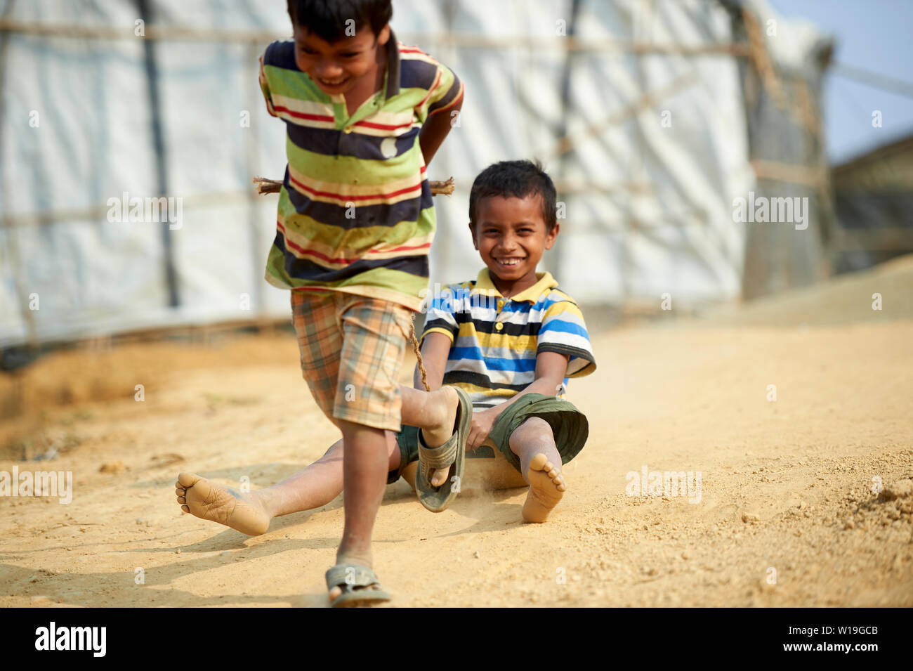 Kind im roten Kleid Sammeln von Brennholz in der Rohingya Flüchtlingslager Kutupalong, Bangladesch Stockfoto