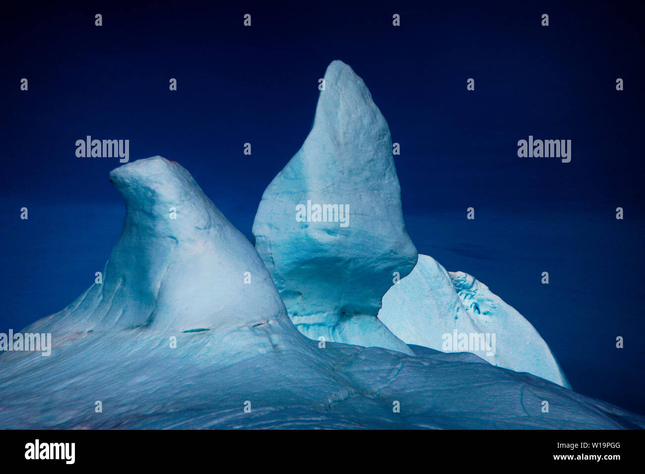 Ansammeln von Eisbergen an der Mündung des Ilulissat-Eisfjords. Nach Angaben von Forschern des Dänischen Meterologischen Instituts schrumpft der grönländische Eisschild mit alarmierender Geschwindigkeit. Fast zehn Kubikkilometer Eis schmilzt jeden Tag, was Süßwasser in den Ozean schleust. Der Eisschild spielt eine wichtige Rolle bei der Abkühlung des Planeten, da 90 Prozent des Sonnenlichts wieder in die Atmosphäre reflektiert werden. Der Verlust des grönländischen Eises aufgrund der vom Menschen verursachten globalen Erwärmung wird den Meeresspiegel um bis zu 20 Fuß erhöhen, die Meeresströmungen stören, indem der Salzgehalt verdünnt wird und die Erwärmung des Planeten beschleunigen. Stockfoto