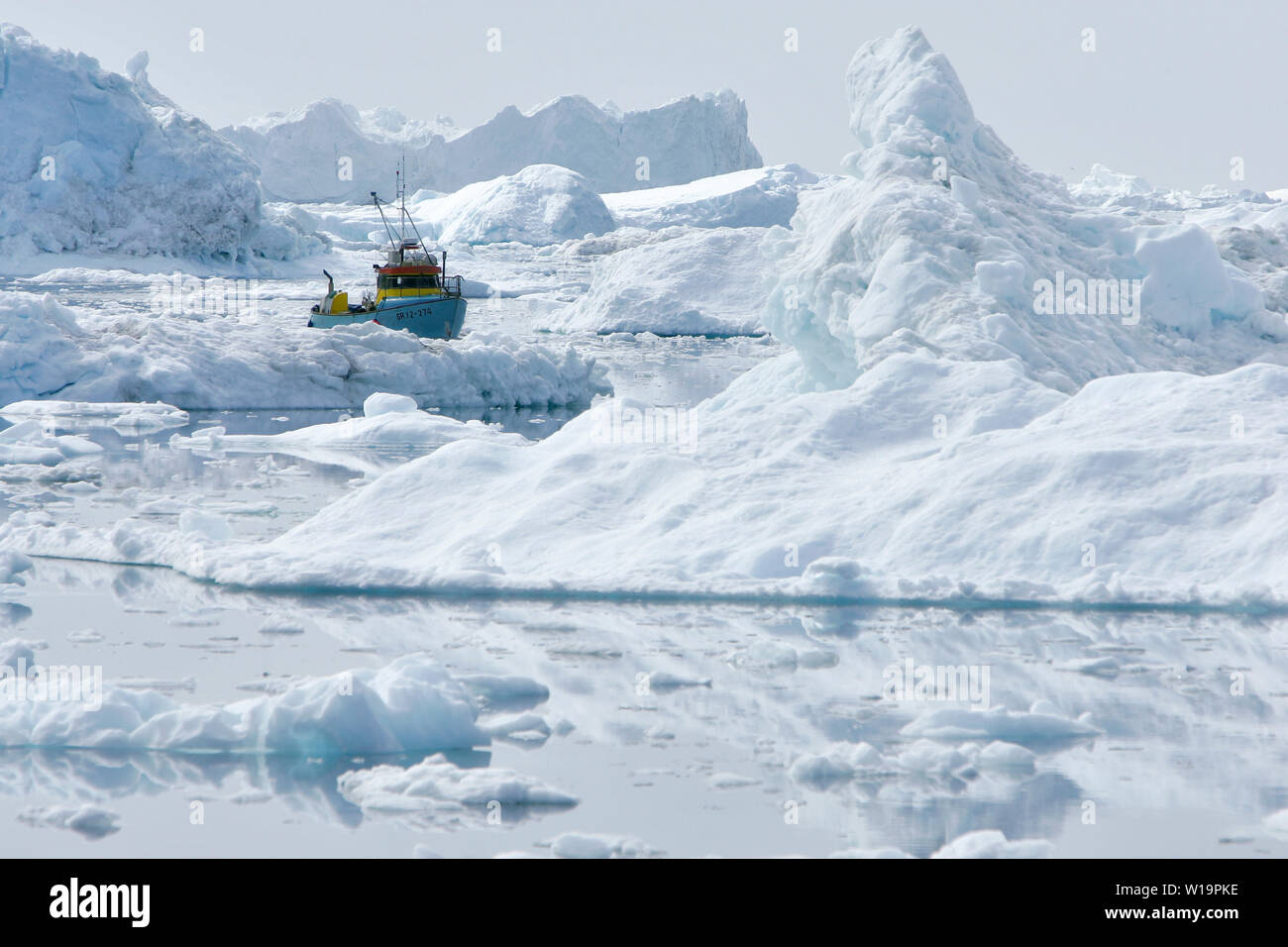 Die Gletscher in Grönland schmelzen. Fischereifahrzeugs Rangieren im Zickzack zwischen den Eisbergen aus der Sermeq Kujalleq Gletscher, alias die Ilulissat Gletscher. Stockfoto