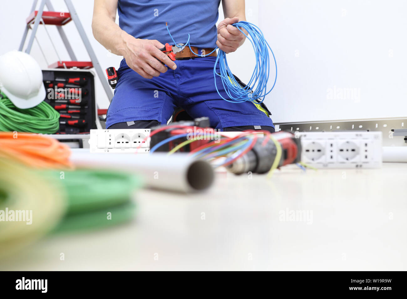 Elektriker bei der Arbeit mit Zange in der Hand schneiden Sie die  elektrischen Kabel, Einbau der elektrischen Stromkreise, elektrische  Verkabelung Stockfotografie - Alamy