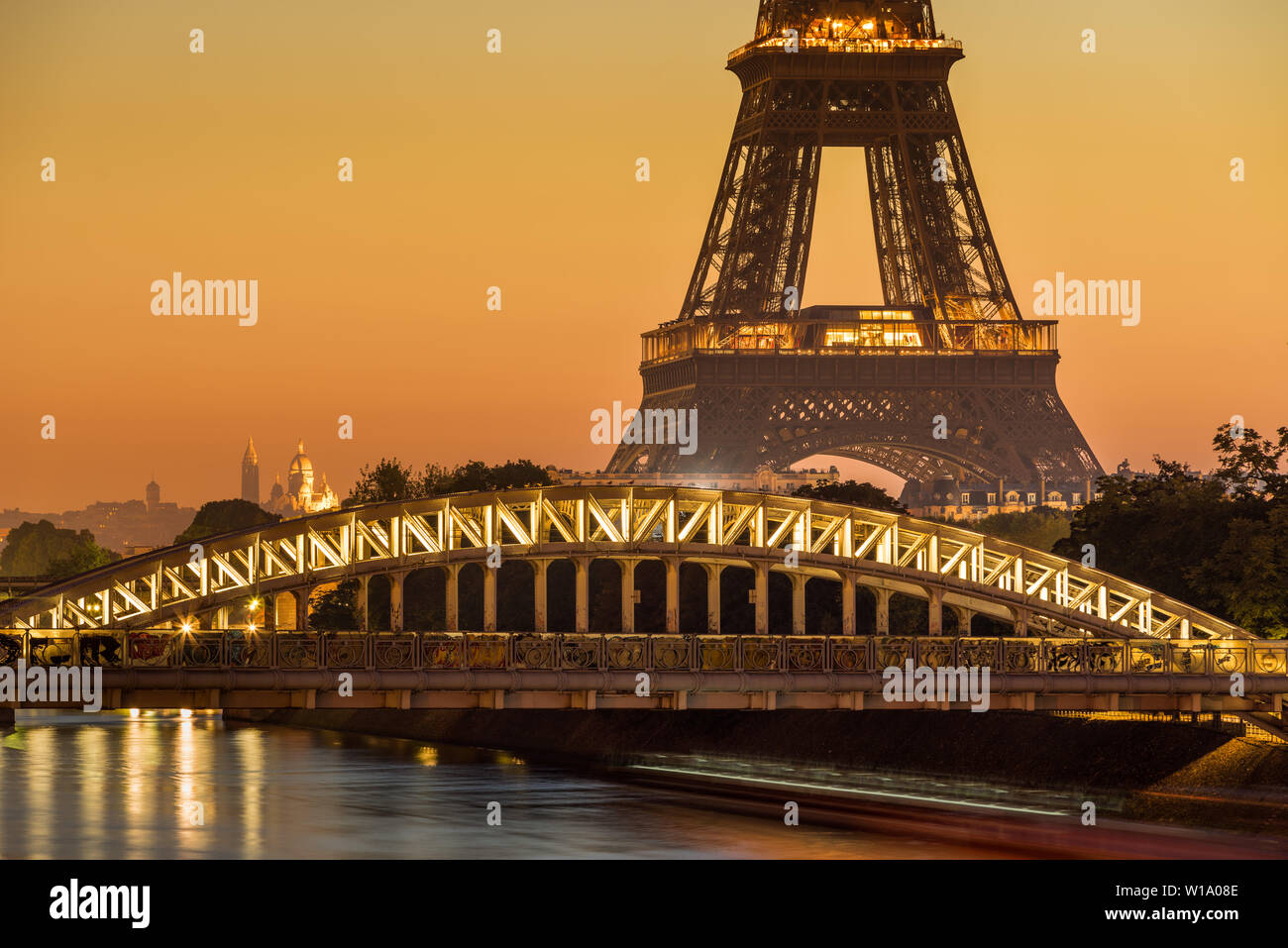 Paris, 75017, FRANKREICH: Eiffelturm und Rouelle Brücke bei Sonnenaufgang mit der Basilika Sacre Coeur in der Ferne. Ile-aux-Cygne Stockfoto