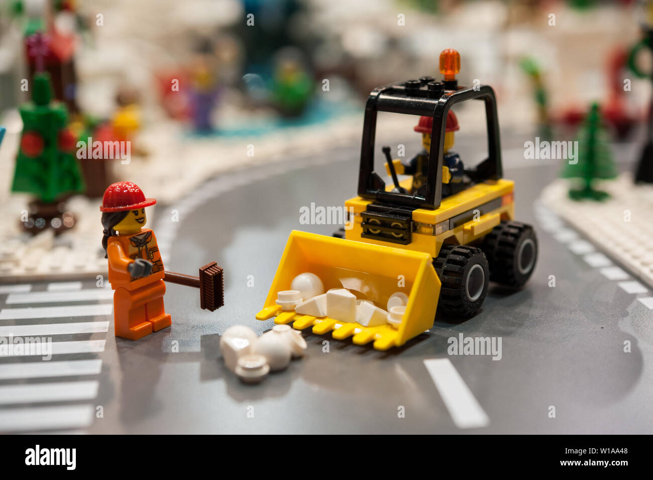 Detail aus Kunststoff Ziegel Modell mit Bulldozer und Beschäftigten im Straßenverkehr. Männer an der Arbeit in einer Stadt Straße. Stockfoto